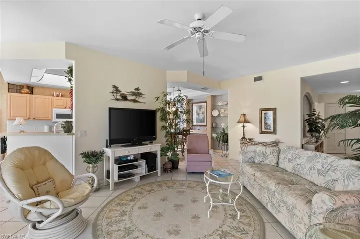 Living room featuring light tile patterned flooring and ceiling fan