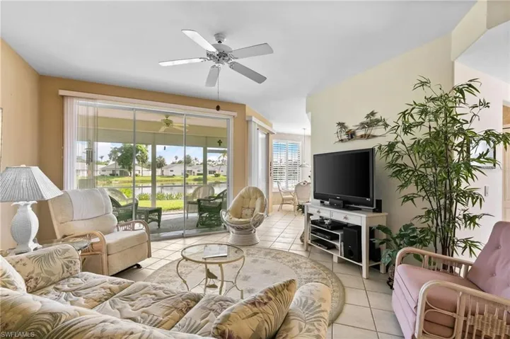 Living room featuring light tile patterned floors and ceiling fan