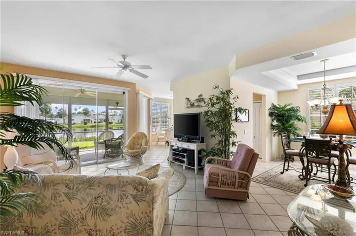 Tiled living room with plenty of natural light and ceiling fan