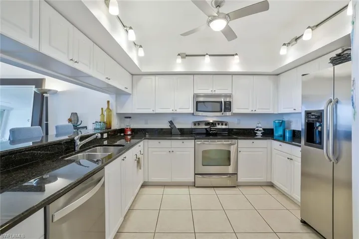 Kitchen featuring stainless steel appliances and white cabinetry