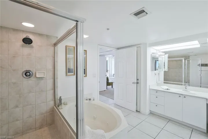 Full bathroom featuring a stall shower, a jetted tub, vanity, tile patterned floors, and recessed lighting