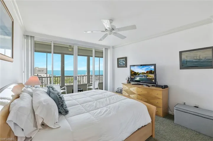 Bedroom featuring ornamental molding, access to exterior, carpet floors, ceiling fan, and expansive windows