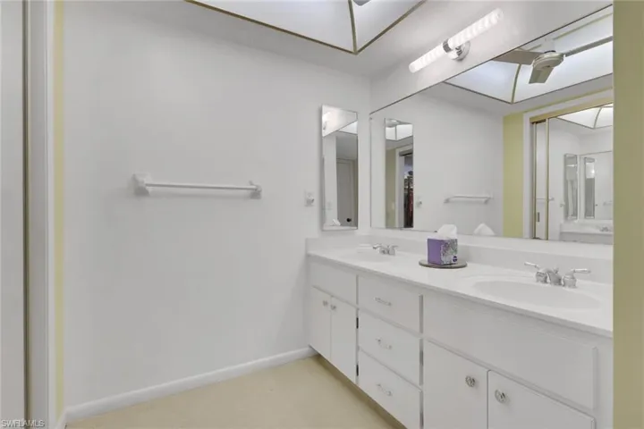 Full bath featuring double vanity and baseboards