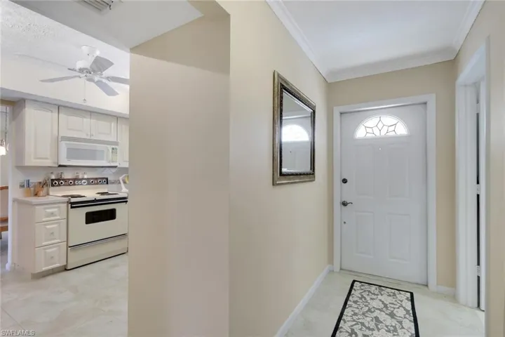 Doorway to outside with ornamental molding and a ceiling fan