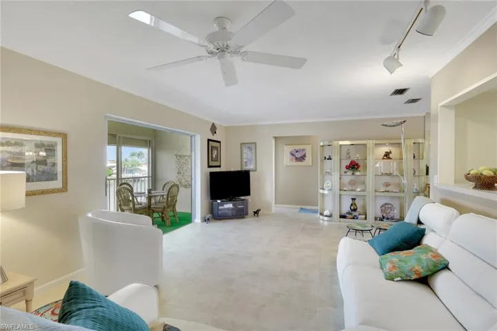 Living area featuring crown molding, rail lighting, and ceiling fan