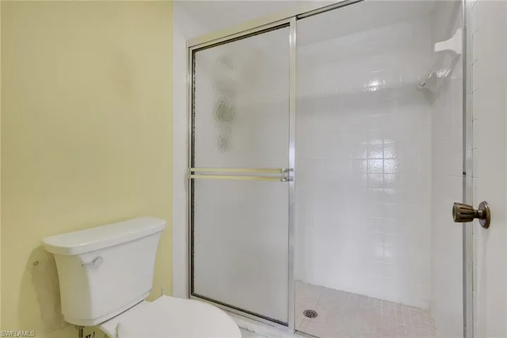 Full bath featuring toilet and a shower stall