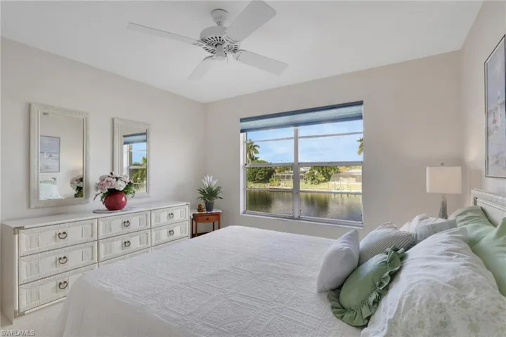 Bedroom featuring a water view and ceiling fan