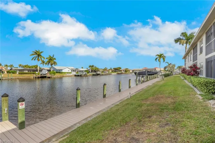Dock featuring a residential view, a water view, a yard, and boat lift
