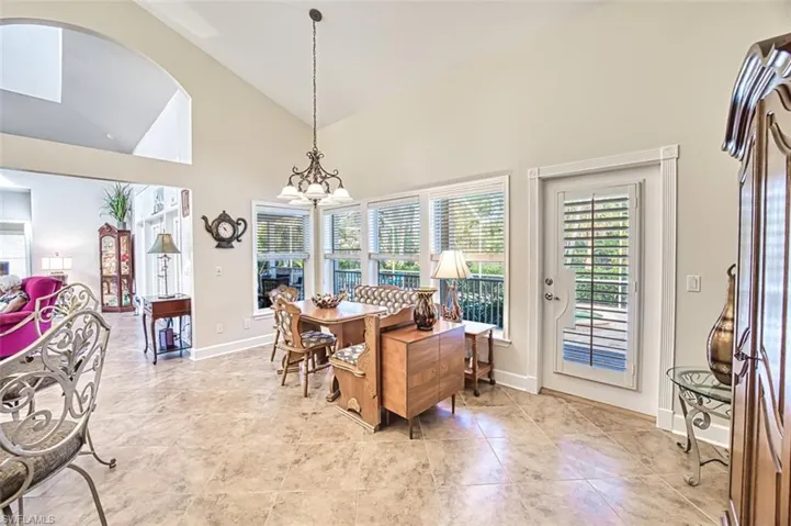Eat in kitchen featuring high vaulted ceiling and a chandelier