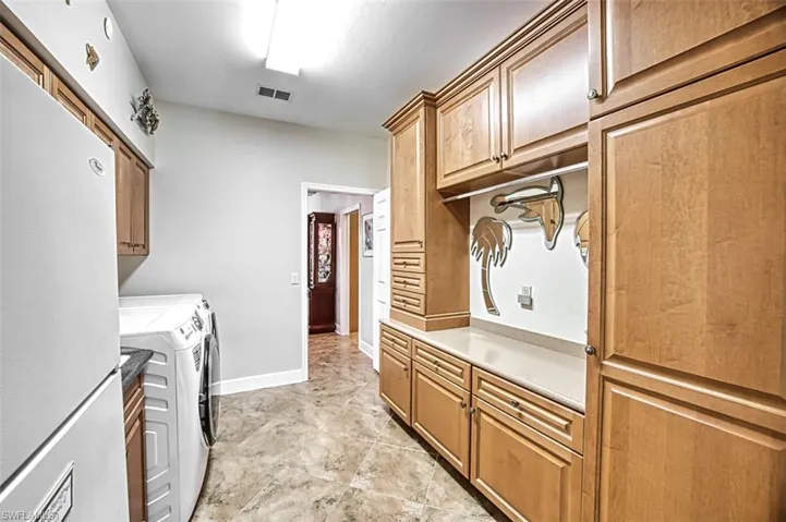 Laundry room with cabinets and washer and clothes dryer