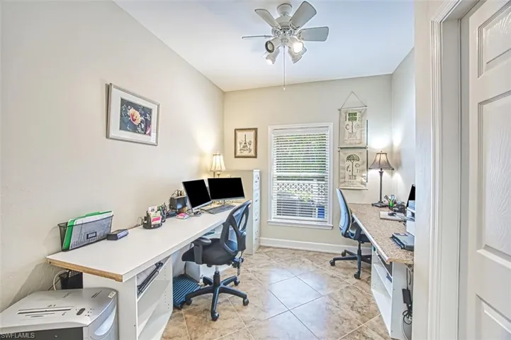 Office area featuring light tile patterned floors and ceiling fan
