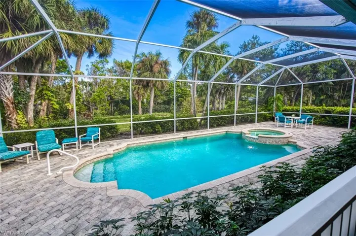 View of swimming pool with a lanai, a patio, and an in ground hot tub