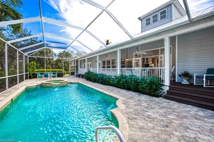 View of swimming pool featuring ceiling fan, a lanai, an in ground hot tub, and a patio area