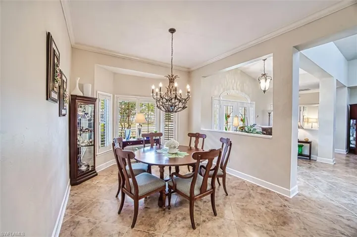 Dining space with a notable chandelier and crown molding