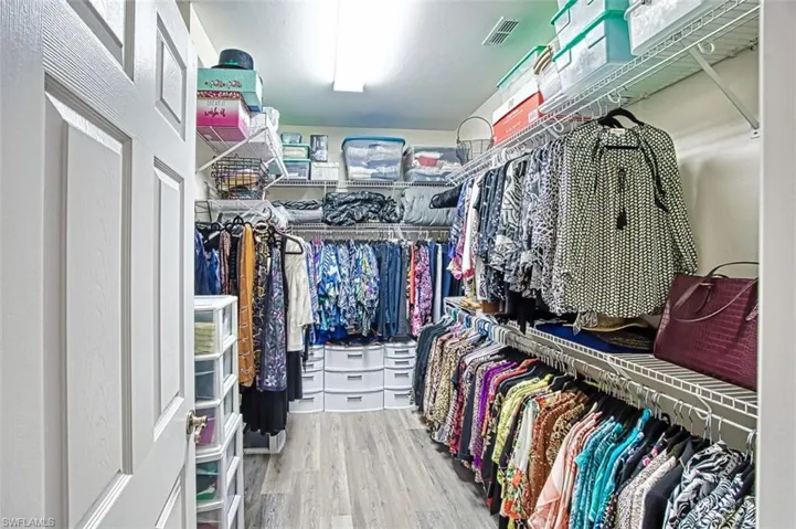Primary spacious closet featuring hardwood / wood-style floors