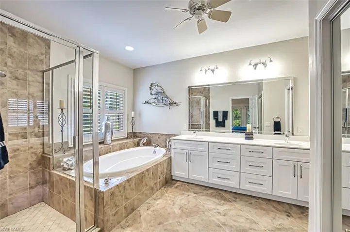Bathroom with plus walk in shower, vanity, tile patterned floors, and ceiling fan