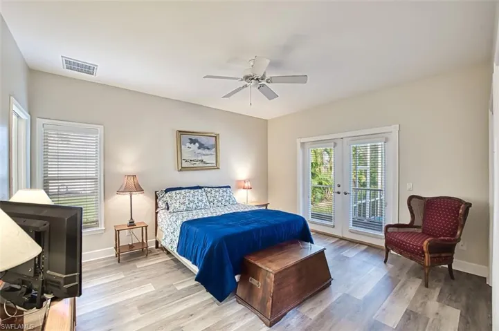 Second bedroom featuring access to exterior, french doors, light hardwood / wood-style floors, and ceiling fan