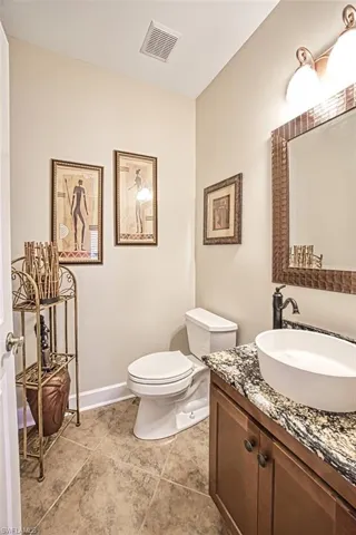 Guest bathroom with toilet, vanity, and tile patterned floors