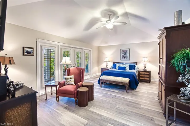 Bedroom with light hardwood / wood-style flooring, lofted ceiling, and ceiling fan