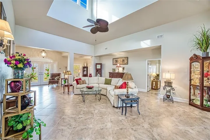 Living room featuring a high ceiling, french doors, and ceiling fan