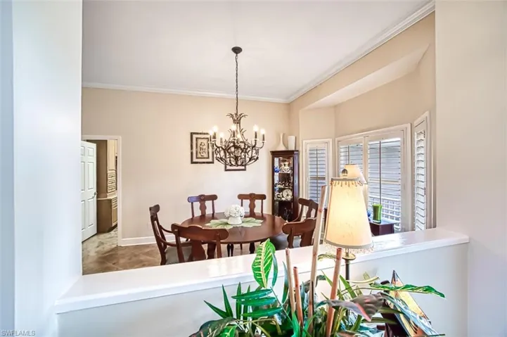 Dining space with a notable chandelier and ornamental molding