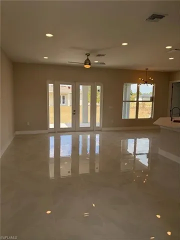 Unfurnished room featuring french doors, ceiling fan, and hanging lights