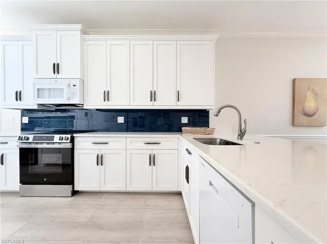 Renovated Kitchen with Tall Shaker Cabinets, Tile Backsplash and Counter  Height Quartz Countertops