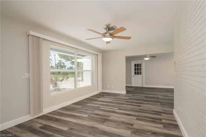 Unfurnished room featuring ceiling fan and dark wood-style flooring