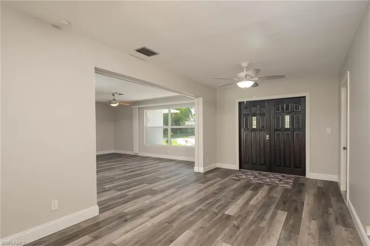 Foyer with ceiling fan and dark wood-type flooring