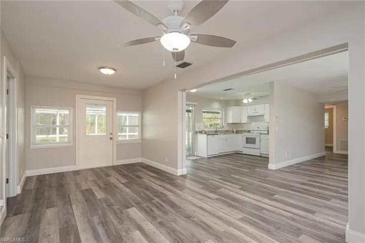 Unfurnished living room with a ceiling fan, wood finished floors, and healthy amount of natural light