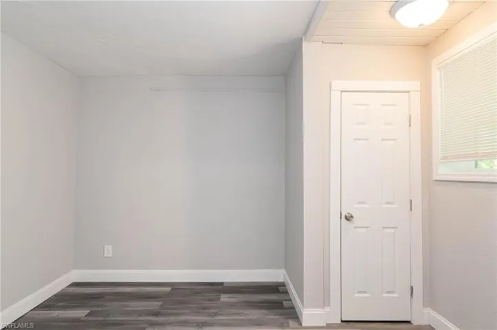 Unfurnished room with dark wood-style floors
