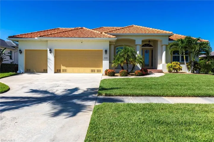 Mediterranean / spanish house featuring an attached garage, stucco siding, a front yard, and a tiled roof