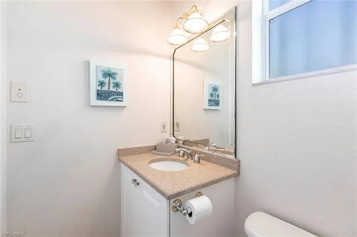 Bathroom featuring a textured wall and vanity