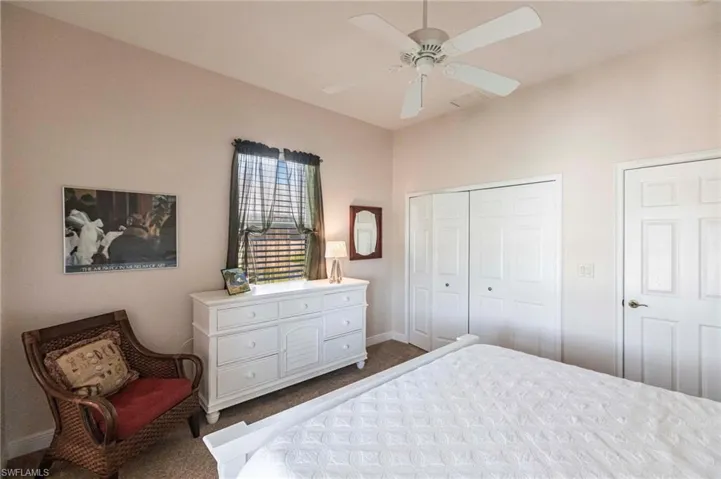 Bedroom featuring dark colored carpet, a closet, and ceiling fan