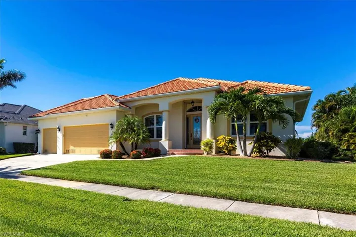 Mediterranean / spanish-style home with stucco siding, a garage, a front yard, and a tiled roof