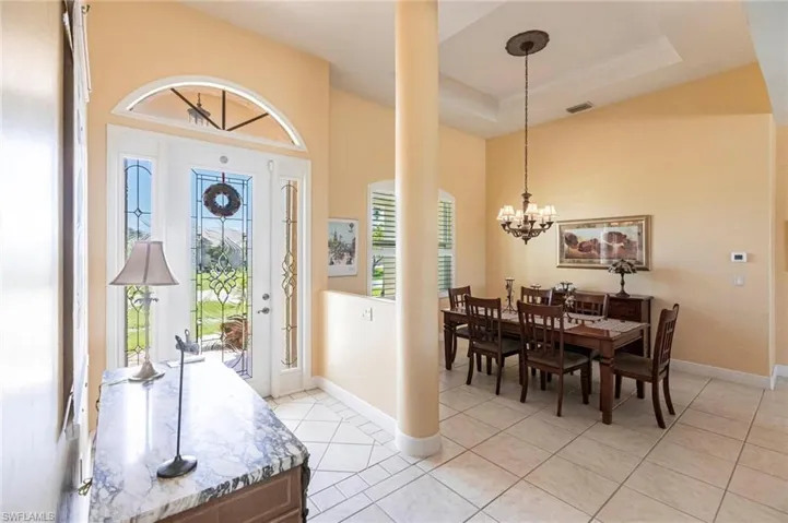 Entryway featuring light tile patterned flooring and a raised ceiling