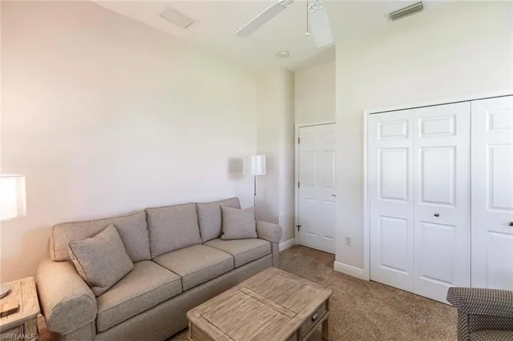 Living area with light carpet and ceiling fan