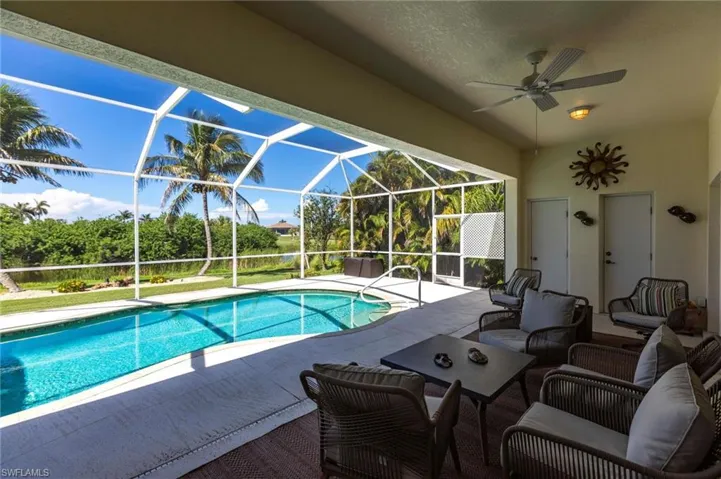 Outdoor pool with glass enclosure, a patio, ceiling fan, and an outdoor hangout area