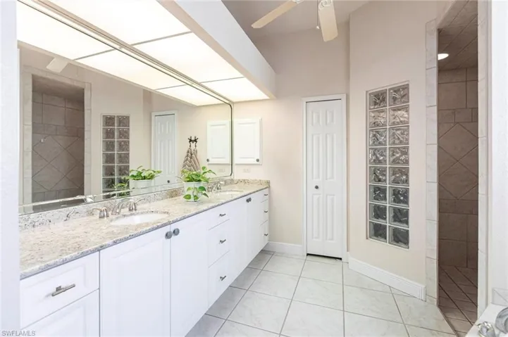 Full bath with double vanity, tile patterned flooring, and ceiling fan