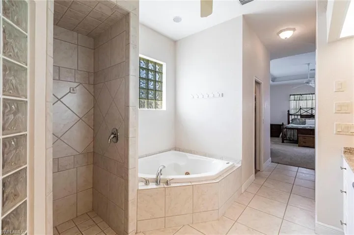 Full bath featuring ceiling fan, connected bathroom, and tile patterned floors