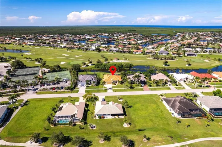 Aerial view of residential area with a large body of water and a golf course