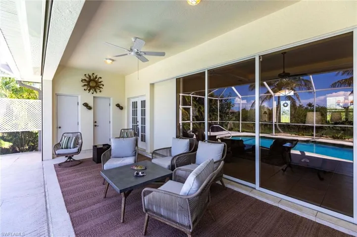 View of patio with an outdoor pool, french doors, outdoor lounge area, a ceiling fan, and glass enclosure