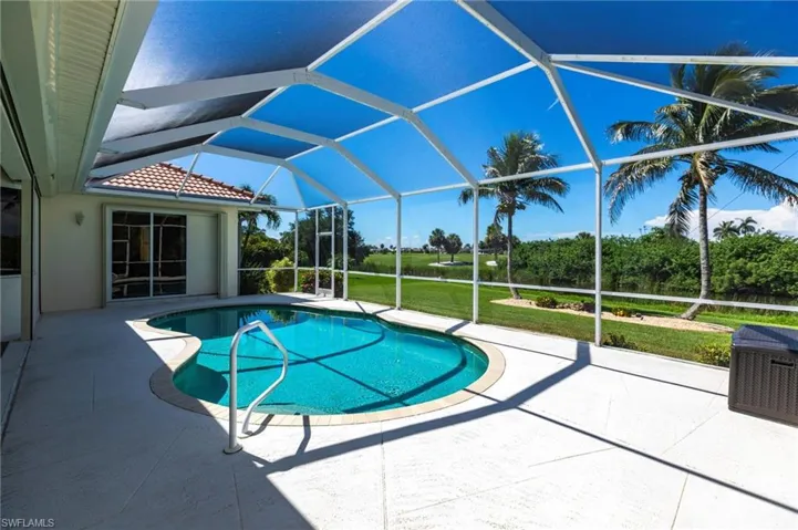 Swimming pool featuring a patio area, a yard, and glass enclosure