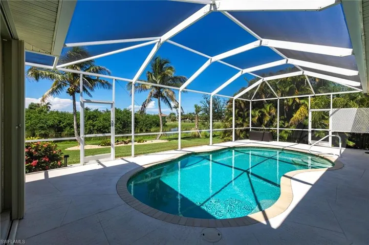 Swimming pool featuring a patio, glass enclosure, and a lawn