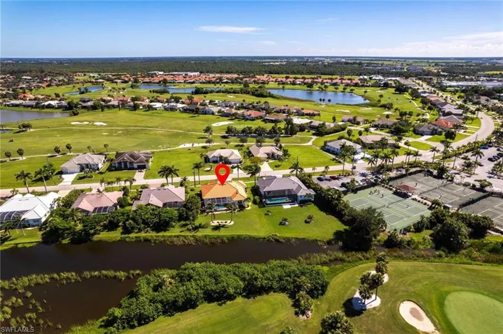 Aerial perspective of suburban area with a golf club and a large body of water