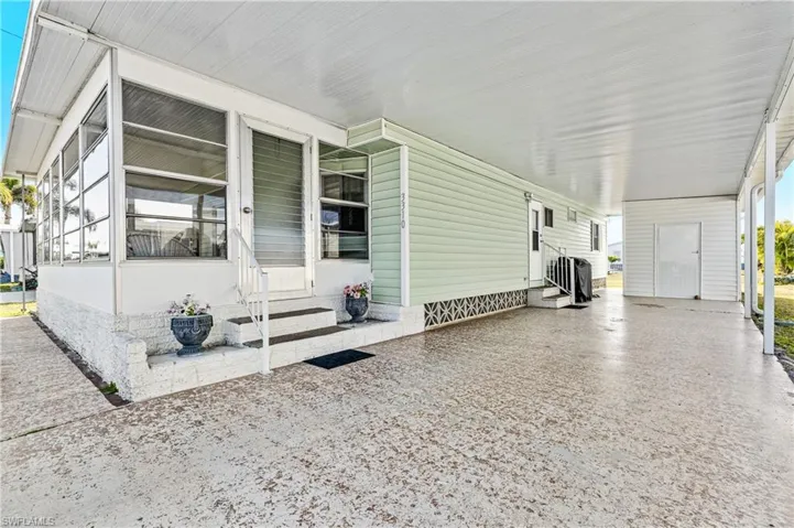 View of side of home with entry steps and a carport