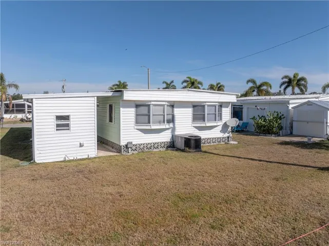 Back of property with a lawn
