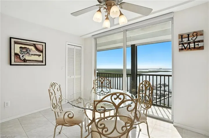 Kitchen with a water view, tile patterned flooring, floor to ceiling windows, and ceiling fan - Virtually Edited Image