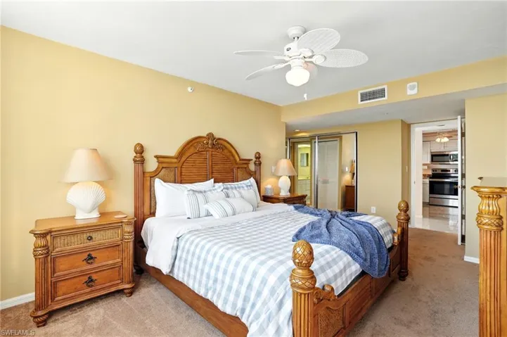 Bedroom featuring a closet, light colored carpet, and ceiling fan - Virtually Edited Image