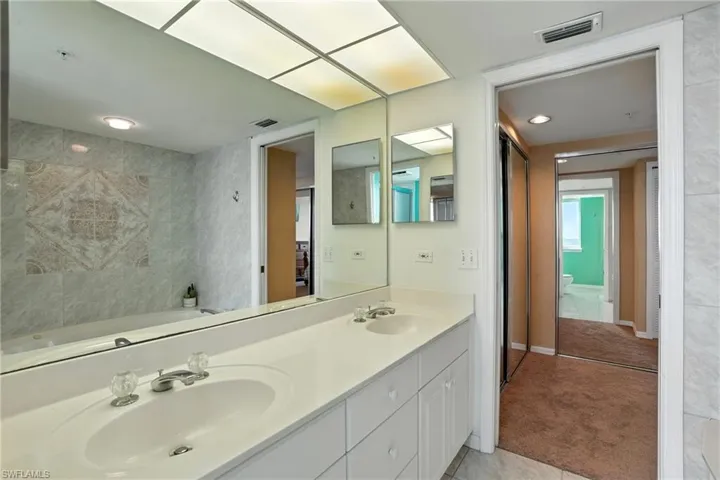 Full bath with double vanity, tile patterned flooring, and a tub - Virtually Edited Image